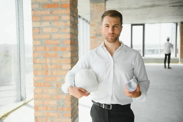 Business architect man wearing hardhat standing of a building project.