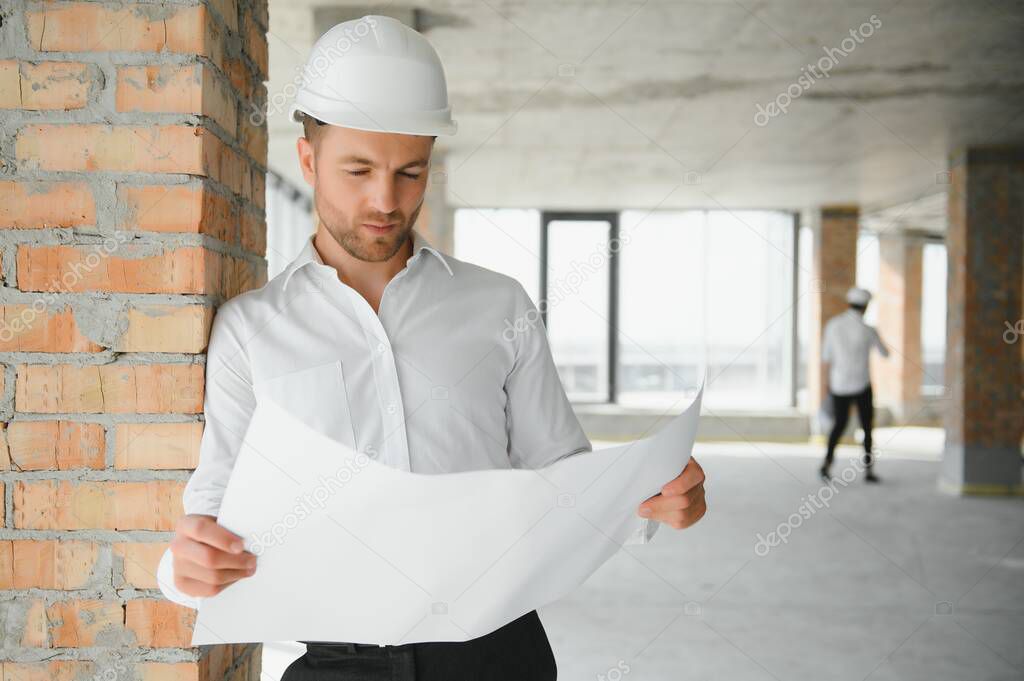 Portrait of man architect at building site. Confident construction manager wearing hardhat. Successful mature civil engineer at construction site with copy space