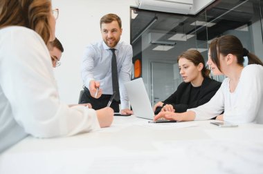 Ofiste proje üzerinde çalışan iş adamları.