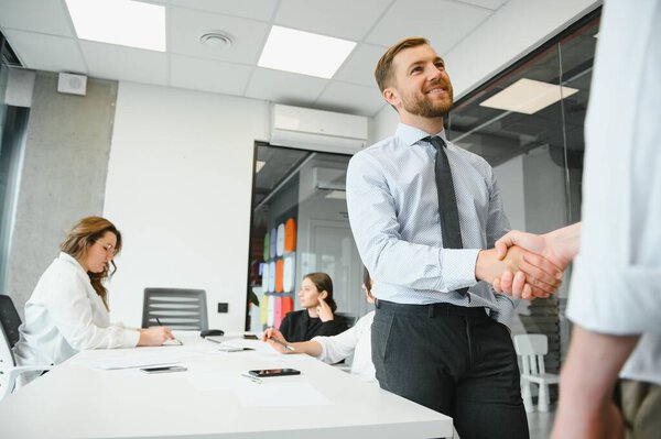 Smiling male business partners negotiators handshake start group office negotiation, company representatives welcoming shake hands at meeting getting acquainted expressing respect make financial deal.