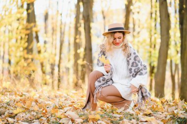 Happy smiling young woman in park on autumn day
