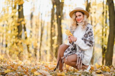 Happy smiling young woman in park on autumn day