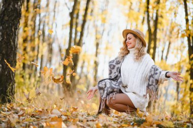 Happy smiling young woman in park on autumn day