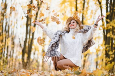 Happy smiling young woman in park on autumn day