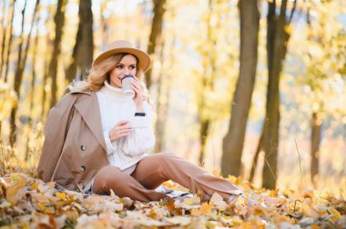 Happy smiling young woman in park on autumn day