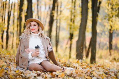 Happy smiling young woman in park on autumn day