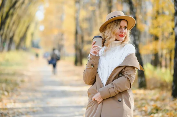 秋の公園でコーヒー カップを持つかなり若い女性 — ストック写真