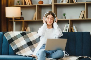 Neşeli, çekici bir insanın uzun bir portresi. Oturup netbook okuyarak evde çalışmanın keyfi yerine geliyor..