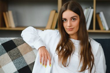 Portrait beautiful young woman relax on sofa in living room interior.