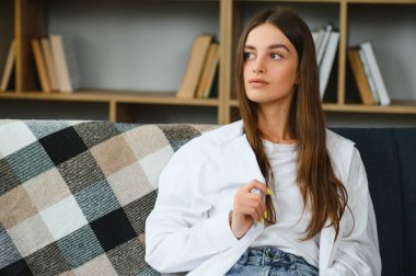 Portrait beautiful young woman relax on sofa in living room interior.