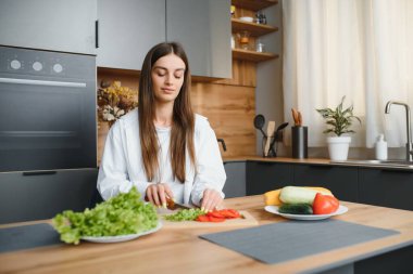 Güzel genç bayan mutfakta sebze salatası hazırlıyor. Sağlıklı yiyecekler. Vejetaryen salatası. Diyet olsun. Diyet Konsepti. Sağlıklı yaşam tarzı. Evde Pişirme