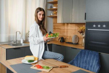 Güzel genç bayan mutfakta sebze salatası hazırlıyor. Sağlıklı yiyecekler. Vejetaryen salatası. Diyet olsun. Diyet Konsepti. Sağlıklı yaşam tarzı. Evde Pişirme