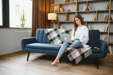 Neşeli, çekici bir insanın uzun bir portresi. Oturup netbook okuyarak evde çalışmanın keyfi yerine geliyor..