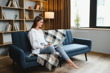 Neşeli, çekici bir insanın uzun bir portresi. Oturup netbook okuyarak evde çalışmanın keyfi yerine geliyor..