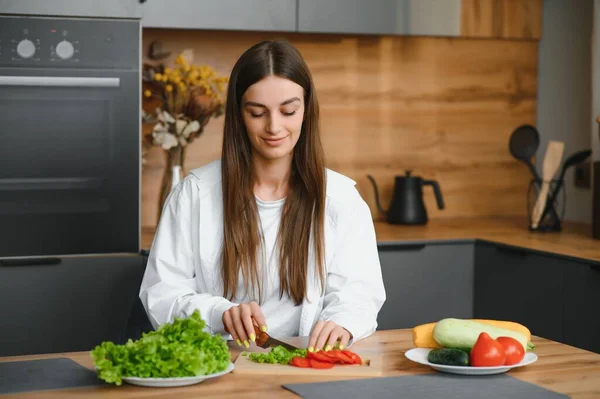 Beautiful European woman preparing a toast of vegetables and microgreens. Nutritionist teaches healthy eating. The vegetarian diet raw food. Dinner of modern people. Cooking sandwich. Girl happy cook
