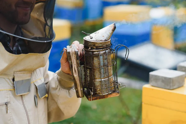 A tools of the beekeeper. Everything for a beekeeper to work with bees. Smoker, a chisel, a box, beekeeper suit for protection from the bees, equipment for beekeeping, beekeeping concept.