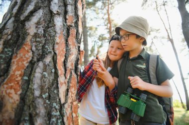 Yeşil ormandaki çocuklar oyun oynuyor, çocuk tatili ve seyahat kavramı.