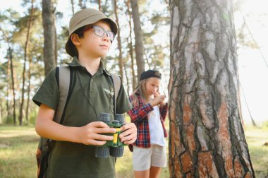 Yeşil ormandaki çocuklar oyun oynuyor, çocuk tatili ve seyahat kavramı.