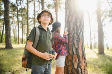 Yeşil ormandaki çocuklar oyun oynuyor, çocuk tatili ve seyahat kavramı.