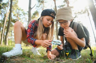 Yeşil ormandaki çocuklar oyun oynuyor, çocuk tatili ve seyahat kavramı.