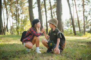 Kids exploring nature with magnifying glass. Summer activity for inquisitive child