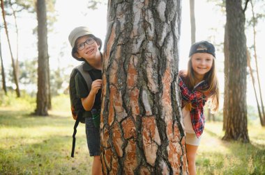 Yeşil ormandaki çocuklar oyun oynuyor, çocuk tatili ve seyahat kavramı.
