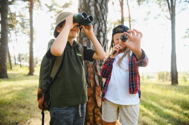 Yeşil ormandaki çocuklar oyun oynuyor, çocuk tatili ve seyahat kavramı.