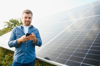 Young architect standing by solar panels.