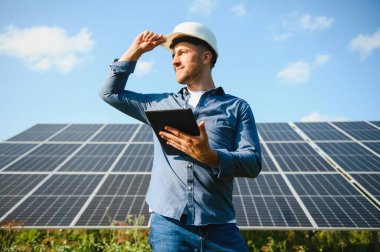 Young architect standing by solar panels.