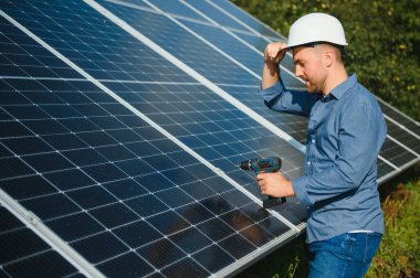 Young architect standing by solar panels.