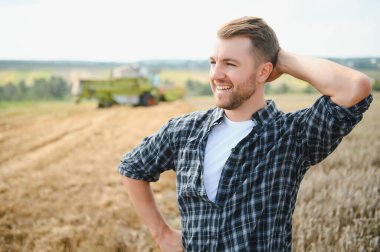 Farmer Standing In Wheat Field At Harvest.