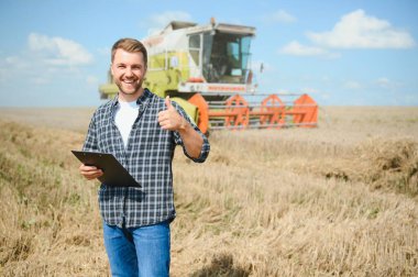 Farmer Standing In Wheat Field At Harvest.