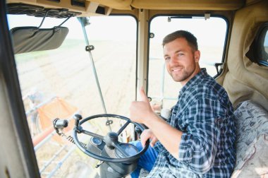 Çiftçi biçerdöveri kontrol ediyor.