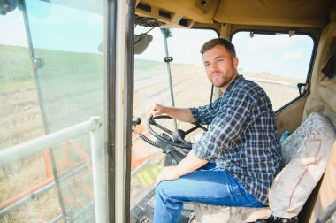 Çiftçi biçerdöveri kontrol ediyor.