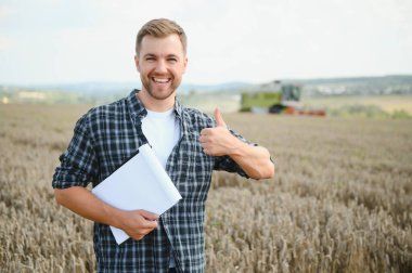 Tablet konumu önünde olan yakışıklı bir çiftçi hasat hasat alanında sırasında birleştirmek