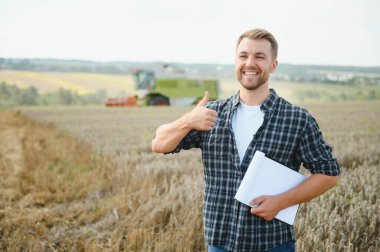 Farmer Standing In Wheat Field At Harvest.