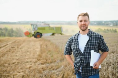 Farmer Standing In Wheat Field At Harvest.