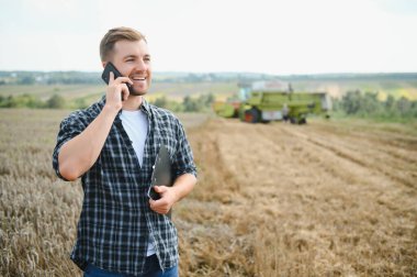 Farmer Standing In Wheat Field At Harvest.