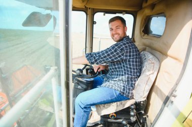 Çiftçi biçerdöveri kontrol ediyor.