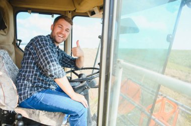 Çiftçi biçerdöveri kontrol ediyor.