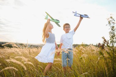 Active running kids with boy holding airplane toy
