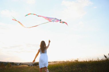 doğada yaz aylarında çayır üzerinde çalışan bir uçurtma ile kız mutlu çocuk.