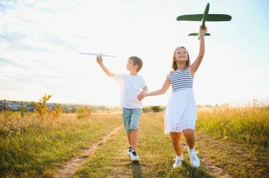 Active running kids with boy holding airplane toy