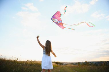 doğada yaz aylarında çayır üzerinde çalışan bir uçurtma ile kız mutlu çocuk.