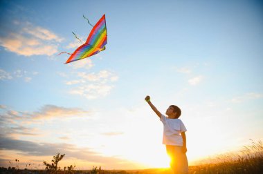Çocuk bütün gün elinde bir uçurtmayla tarlada koşuyor..