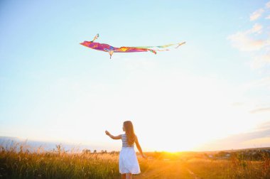 küçük şirin 7 yıl yaşlı kız yaz gününde uçurtma ile alanında çalışan.