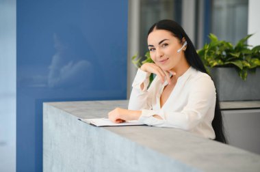 Brunette woman receptionist working in Reception of the beauty salon