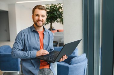 Handsome young businessman, using a laptop in the cafe