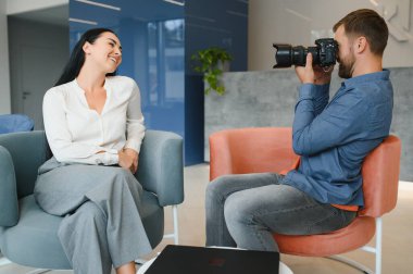 Male photographer taking picture of young woman.