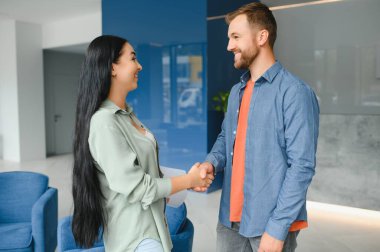 Two business coworkers walking through a lobby of an office building.